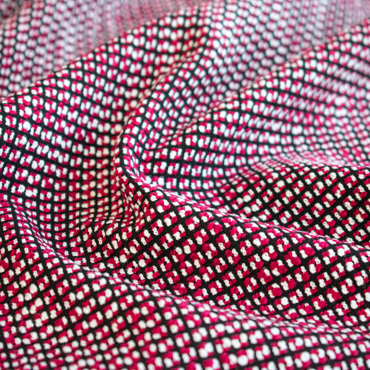 Close-up of Couture fabric with red, black, and white pattern
