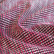 Close-up of Couture fabric with red, black, and white pattern