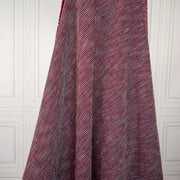 Couture red and black textured woven fabric draped on dress form.