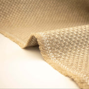Close-up of Couture Designer Golden Champagne Italian Wool Woven fabric on a white background