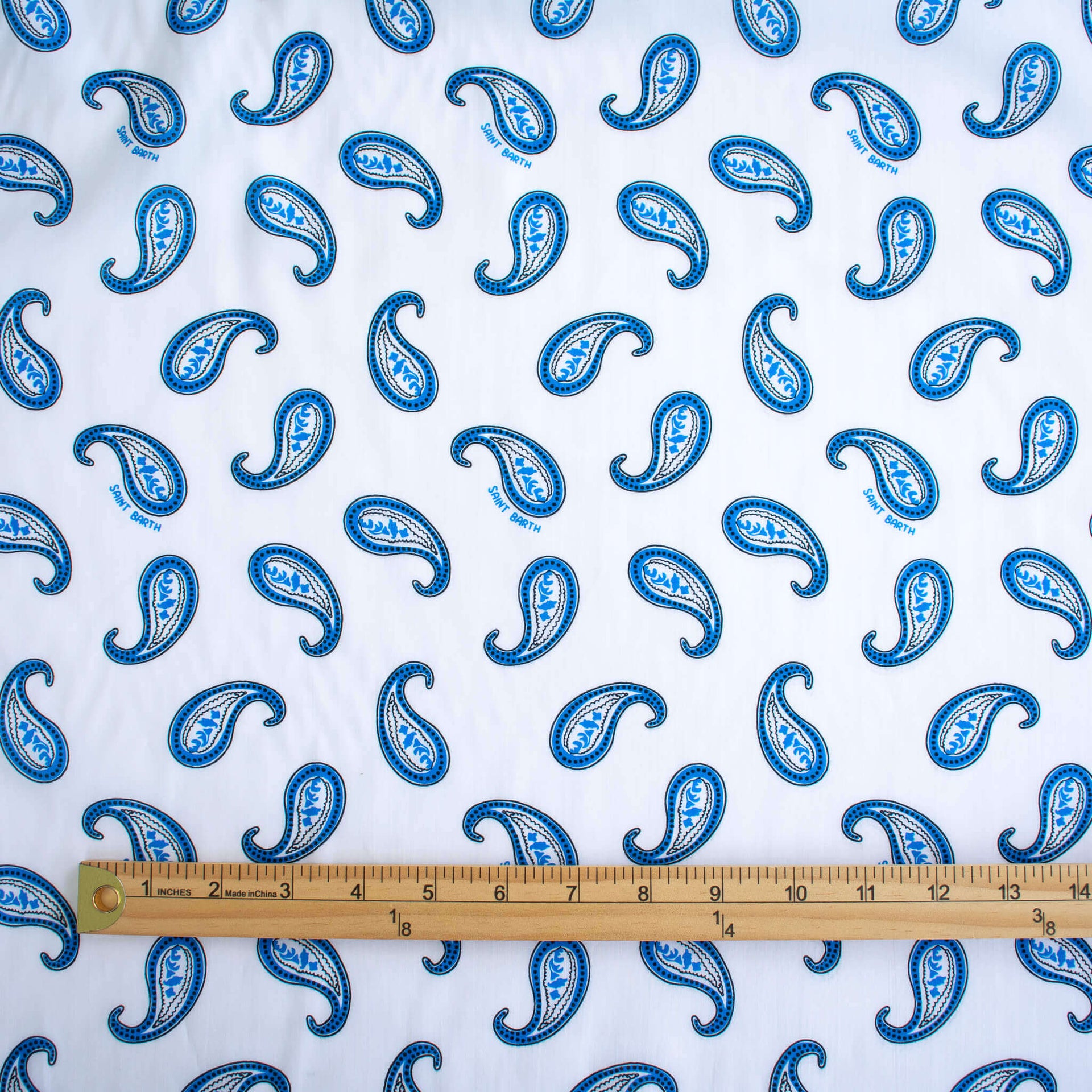 Image of Italian Blue and white paisley print cotton woven fabric with ruler for scale.