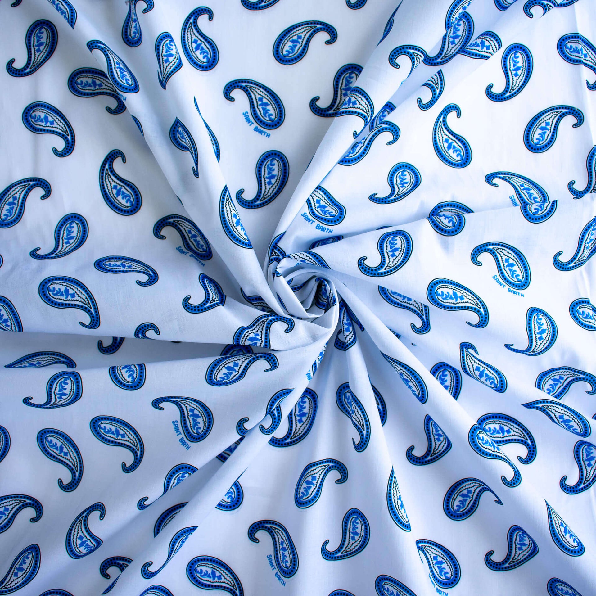Image of Italian Blue and white paisley print cotton woven fabric demonstrating fabric fullness.