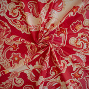 Image of Italian Viscose Coral Red Paisley woven fabric by the yard. Twirled to show fabric fullness.