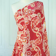 Italian Viscose Coral Red Paisley woven fabric by the yard draped on dress form.
