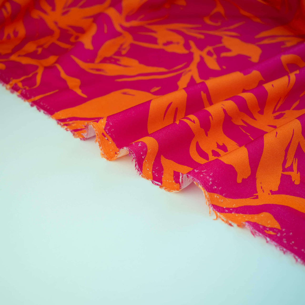 Italian Viscose fabric by the yard in a tropical leaf print - Image of selvedge.