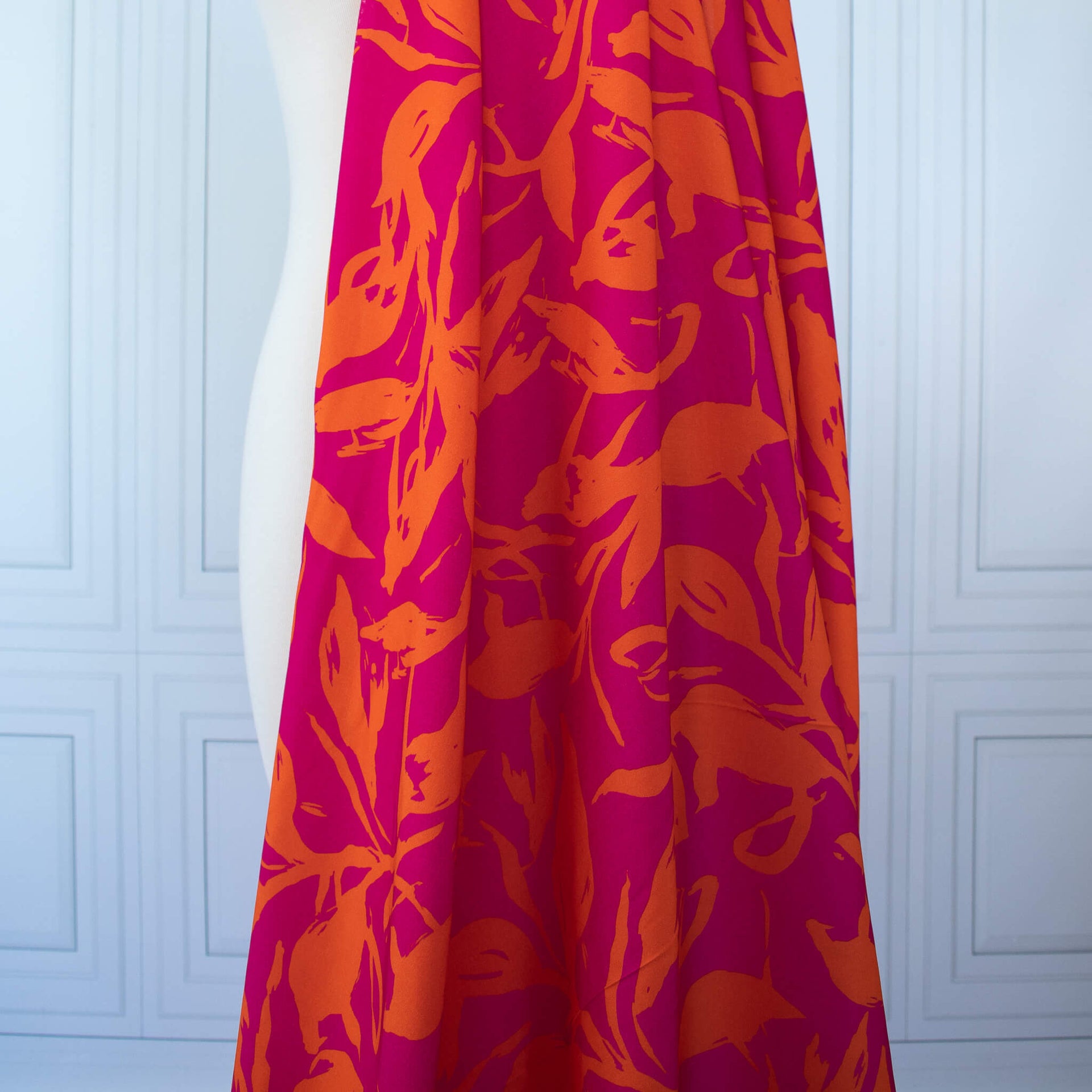  Italian Viscose fabric by the yard in a tropical leaf print draped on dress form.
