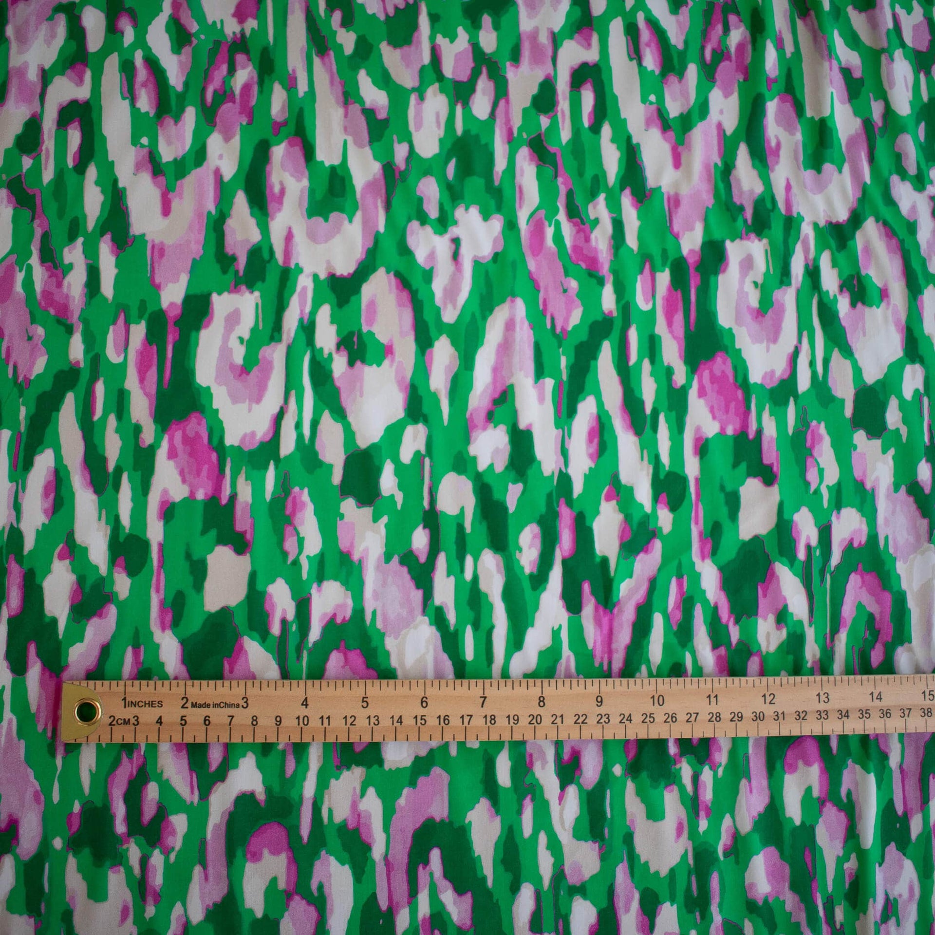 A close-up of Italian Viscose Woven Abstract Print fabric with ruler placed along the bottom edge for scale.