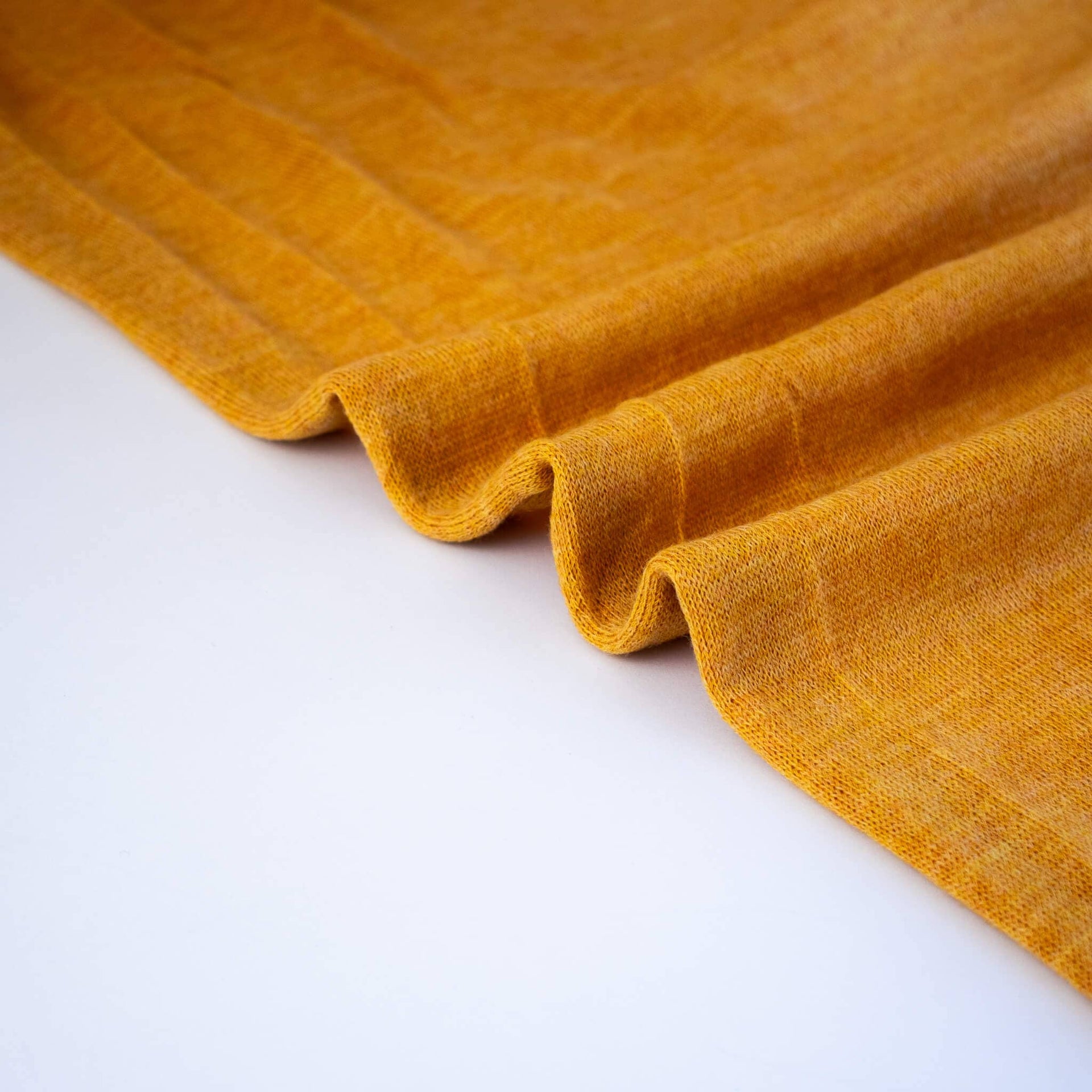 Image of Fine Italian Wool Knit Jersey fabric by the yard in golden saffron selvedge.
