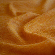 Close up image of Fine Italian Wool Knit Jersey fabric by the yard in golden saffron.