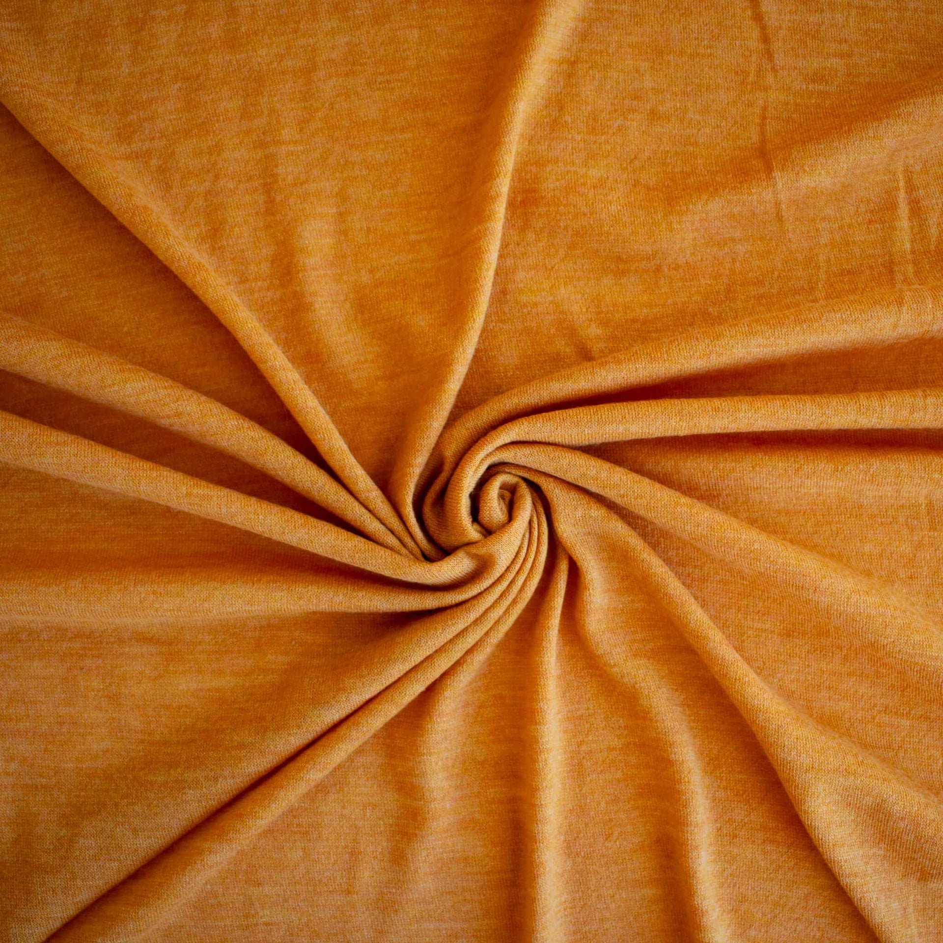 Fine Italian Wool Knit Jersey fabric by the yard in golden saffron. Image of fabric fullness.