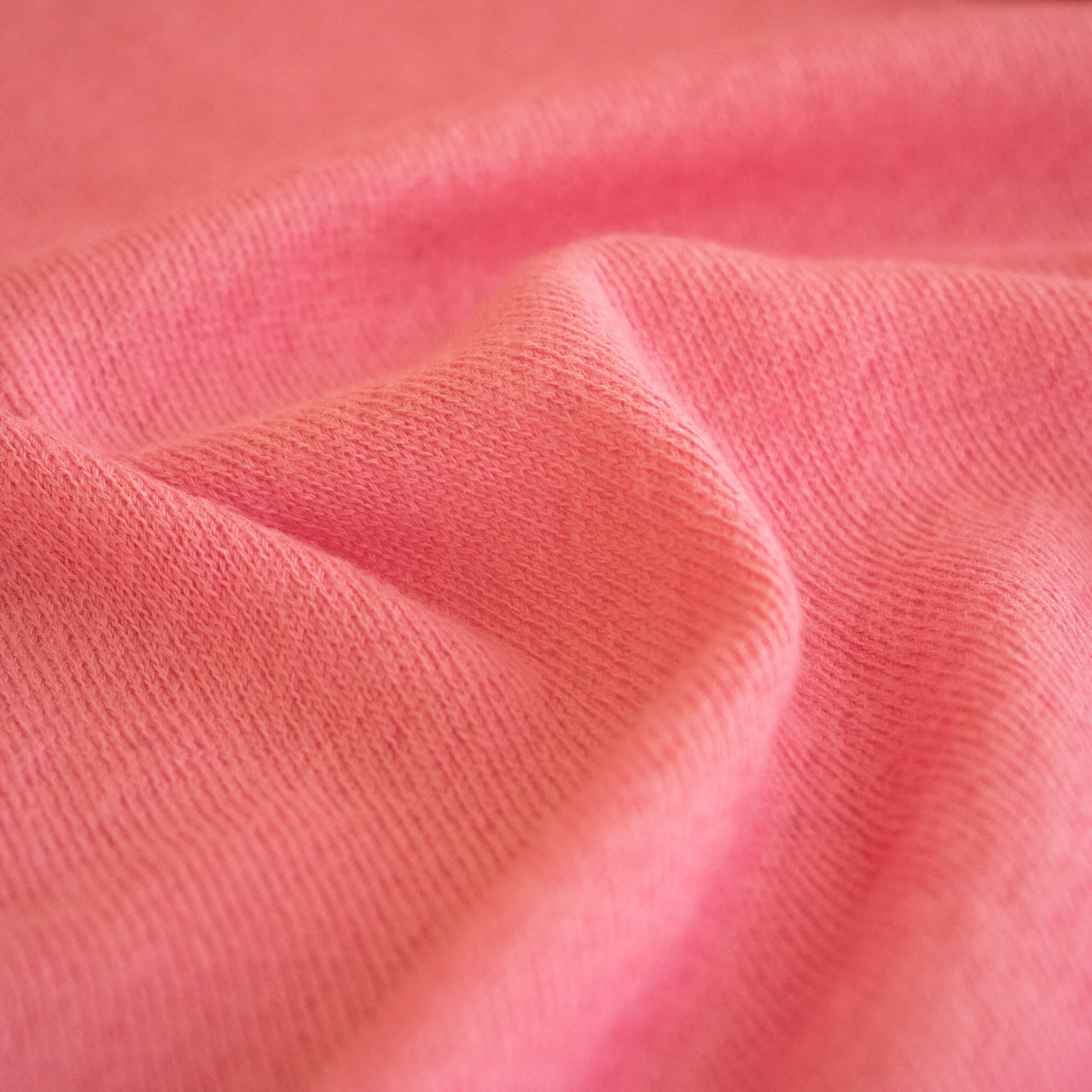 A close-up of Fine Italian Wool Jersey knit fabric by the yard in Pink Blush.