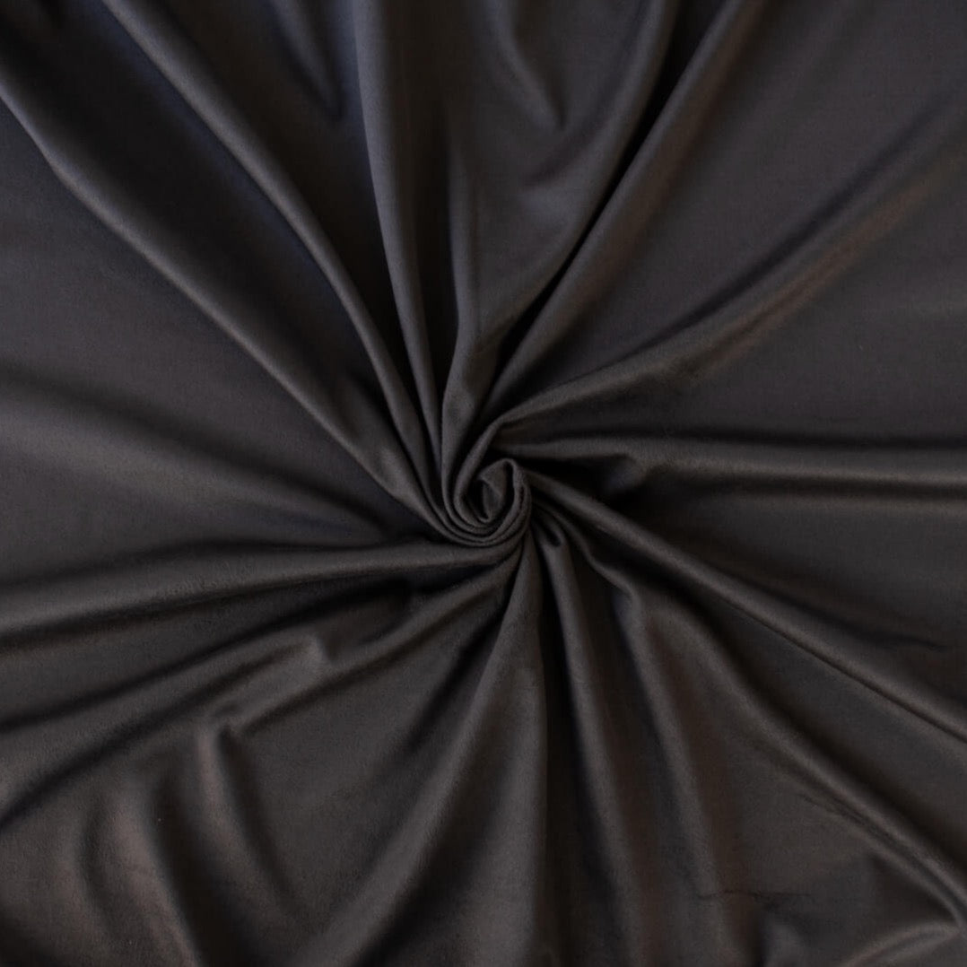 Faux Suede Knit fabric by the yard in a neutral truffle brown color . It has a soft hand, elegant drape and tons of edgy sophistication! Faux suède has a soft napped surface which requires cutting your fabric out in a one-way nap direction. Image of fabric body.