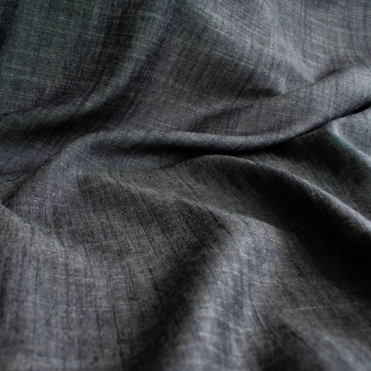  Stay cool and look amazing while you enjoy the breathability and sustainability of Tencel and all you love about linen in one gorgeous dark indigo fabric.&nbsp;  On the lighter side of a mid-weight with a beautiful sheen, nice drape, and softly textured hand you'll look 'Tres Chic'!  Close up image.