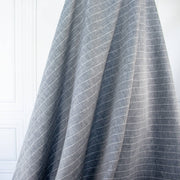 Cotton/Linen Chambray fabric by the yard. On the lighter side of mid-weight, this woven dark navy chambray features a white vertical pinstripe, a nice comfortable hand, and a lovely drape.  Image of fabric drape.