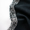 Exquisite Mokuba passementerie trim in black and silver chenille ribbons perfect for your next couture classic French jacket. Close up of trim displayed upon black boucle fabric.