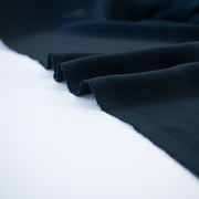 Become a fashionista with this NYC designer 100% silk double georgette Prussian blue fabric by the yard. A designer deadstock fabric that is flowy, with a textured hand, and can be cut on the bias for a stunning top, dress, or skirt!  Image of selvedge.