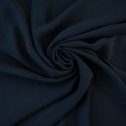 Become a fashionista with this NYC designer 100% silk double georgette Prussian blue fabric by the yard. A designer deadstock fabric that is flowy, with a textured hand, and can be cut on the bias for a stunning top, dress, or skirt!  Image of fabric body.