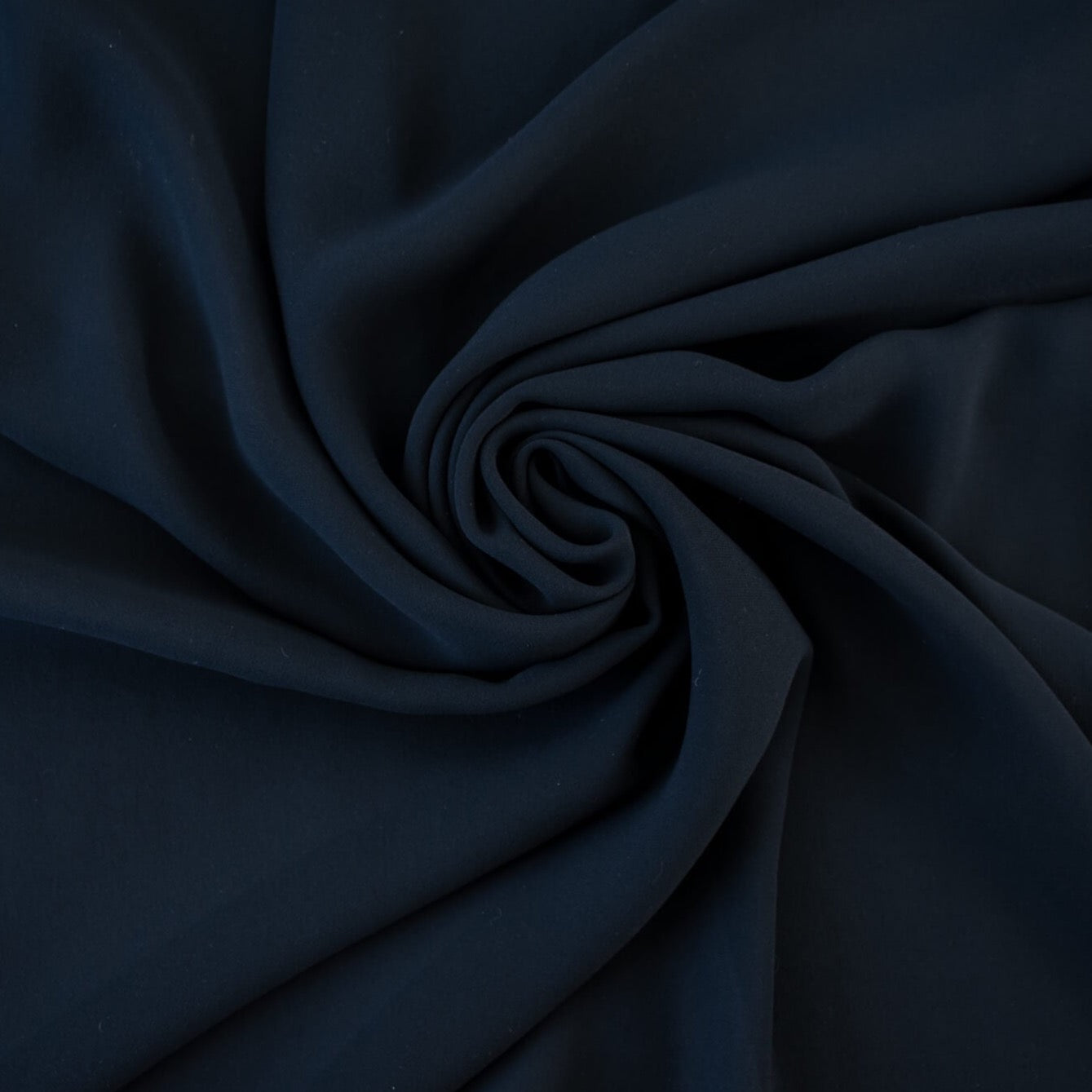 Become a fashionista with this NYC designer 100% silk double georgette Prussian blue fabric by the yard. A designer deadstock fabric that is flowy, with a textured hand, and can be cut on the bias for a stunning top, dress, or skirt!  Image of fabric body.