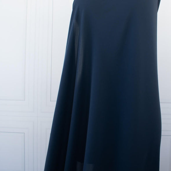 Become a fashionista with this NYC designer 100% silk double georgette Prussian blue fabric by the yard. A designer deadstock fabric that is flowy, with a textured hand, and can be cut on the bias for a stunning top, dress, or skirt!  Image of fabric drape on dressform.