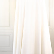 High-End Designer Pearl White Ponte Knit fabric by the yard. This Los Angeles designer has a knack for finding quality fabrics. This designer deadstock Ponte is soft with a nice drape that falls moderately close to the body. You'll fall in love with the comfort! Image of fabric drape.