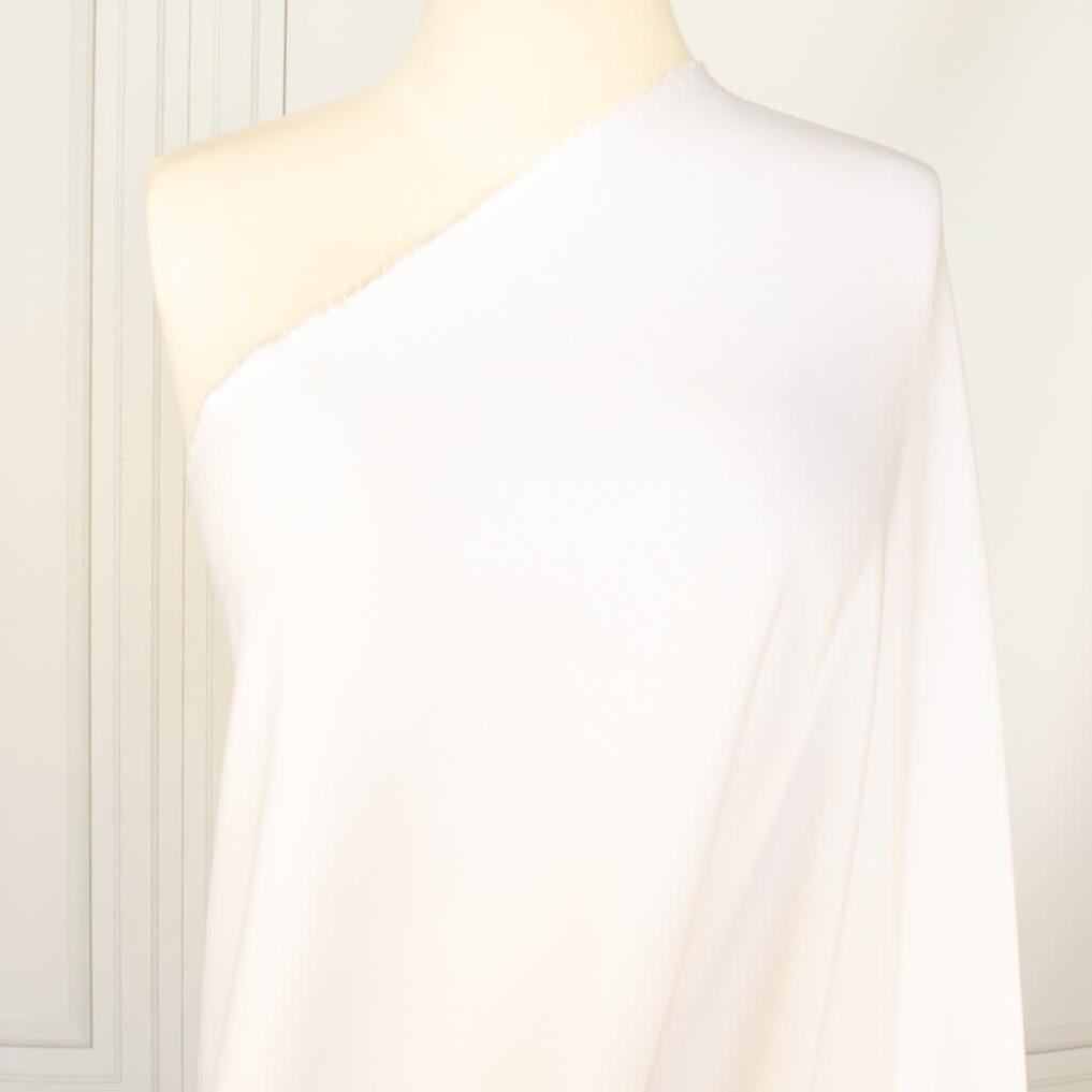 High-End Designer Pearl White Ponte Knit fabric by the yard. This Los Angeles designer has a knack for finding quality fabrics. This designer deadstock Ponte is soft with a nice drape that falls moderately close to the body. You'll fall in love with the comfort! Image of fabric on dressform.
