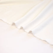 High-End Designer Pearl White Ponte Knit fabric by the yard. This Los Angeles designer has a knack for finding quality fabrics. This designer deadstock Ponte is soft with a nice drape that falls moderately close to the body. You'll fall in love with the comfort! Image of selvedge.