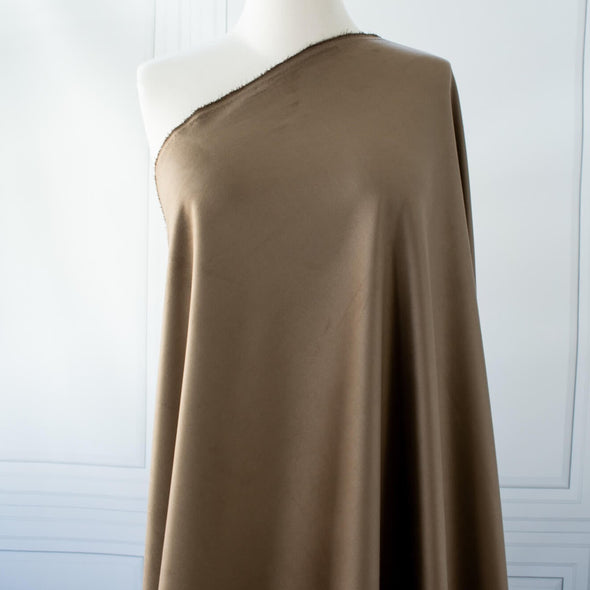 Take your projects up a notch with our Faux Suede Knit fabric by the yard in a soft brown we call "Haute Chocolate". Luxuriously smooth and endlessly fabulous, it's the perfect fabric to add a subdued edge to your "Haute" look! Image of fabric draped on dressform.