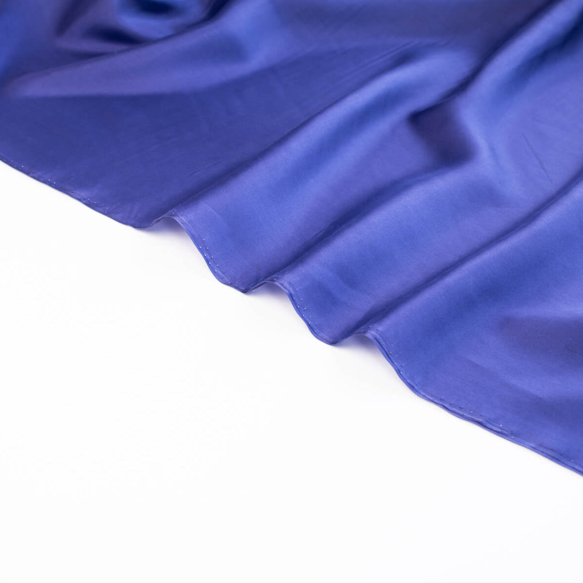 'Violet' Royal Blue 100% China Silk fabric by the yard. Lightweight and translucent, its soft hand and delicate drape make it perfect for tops and especially for lining your couture hand-made garments. Made from 100% silk, this fabric is sure to add a touch of luxury to your sewing project. Close up image of selvedge.