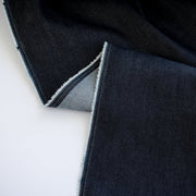 Get the perfect blend of comfort and style with our Midnight Navy Cotton Stretch Denim Twill fabric by the yard. &nbsp;A denim you can dress up with its deep rich dark blue color and crisp, semi-textured hand. Image of selvedge.
