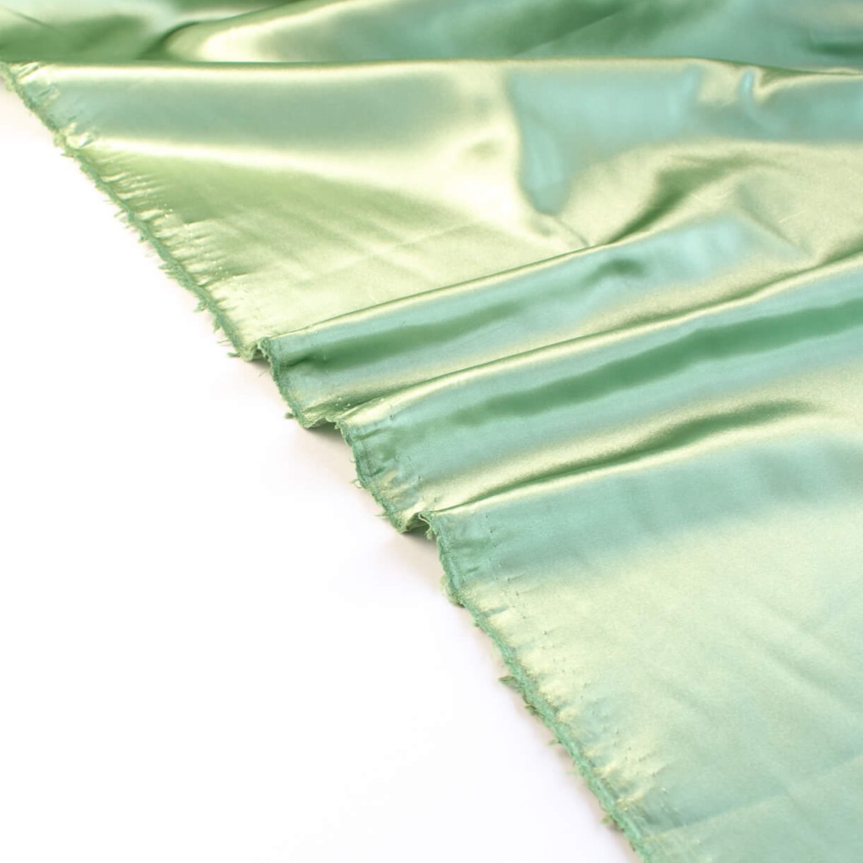 NYC Designer Polyester Satin designer deadstock fabric by the yard. Shimmery satin in a serene spring green is sophisticated and eye catching! &nbsp;This opaque, tightly woven fabric falls moderately away from the body. Image of selvedge.