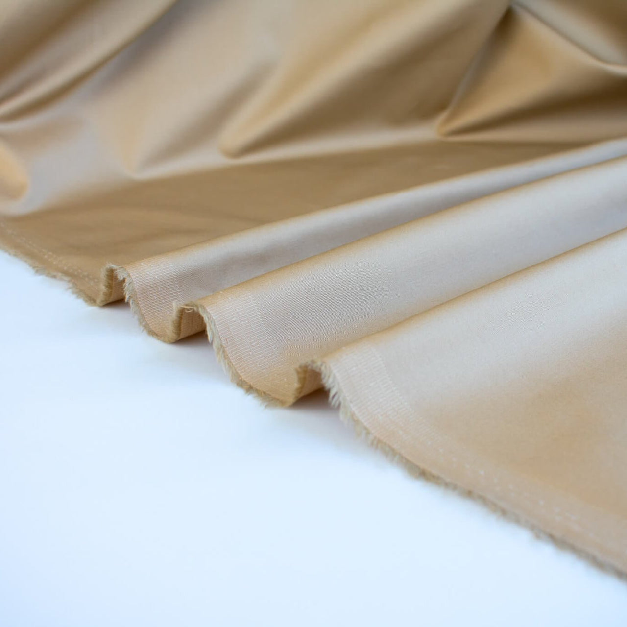 Looking to create a more 'Mindful' wardrobe? You'll love our Cotton Stretch Sateen - a designer deadstock fabric by the yard with a touch of spandex for the perfect amount of stretch. Image of selvedge.