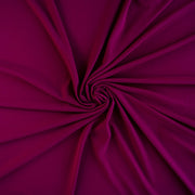 Famous Designer Poly/Spandex ITY Knit in 'Berry Rich'! This designer deadstock fabric by the yard boasts a rich berry color that is sure will elevate any project. Its smooth hand and elegant drape is a must have for comfort and style. Image of fabric fullness.