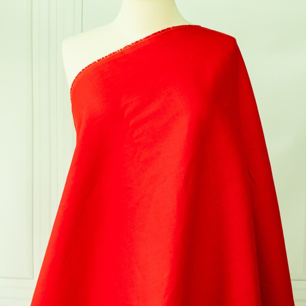 Red mid-weight linen fabric by the yard is just plain gorgeous. The fabric has a soft hand, slight slubbing, and the mid-weight makes it a perfect choice for tailored garments such as jackets and fitted sheath dresses or suitings. Image of fabric draped on dressform.