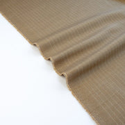 This elegant NYC Designer Pinstripe Twill designer deadstock fabric by the yard is the perfect choice for those who appreciate understated elegance. The gorgeous combination of tan highlighted by a white pinstripe features a soft, textured hand and falls moderately away from the body. A perfect choice if you will be sewing up a trouser, or suiting. Image of selvedge.