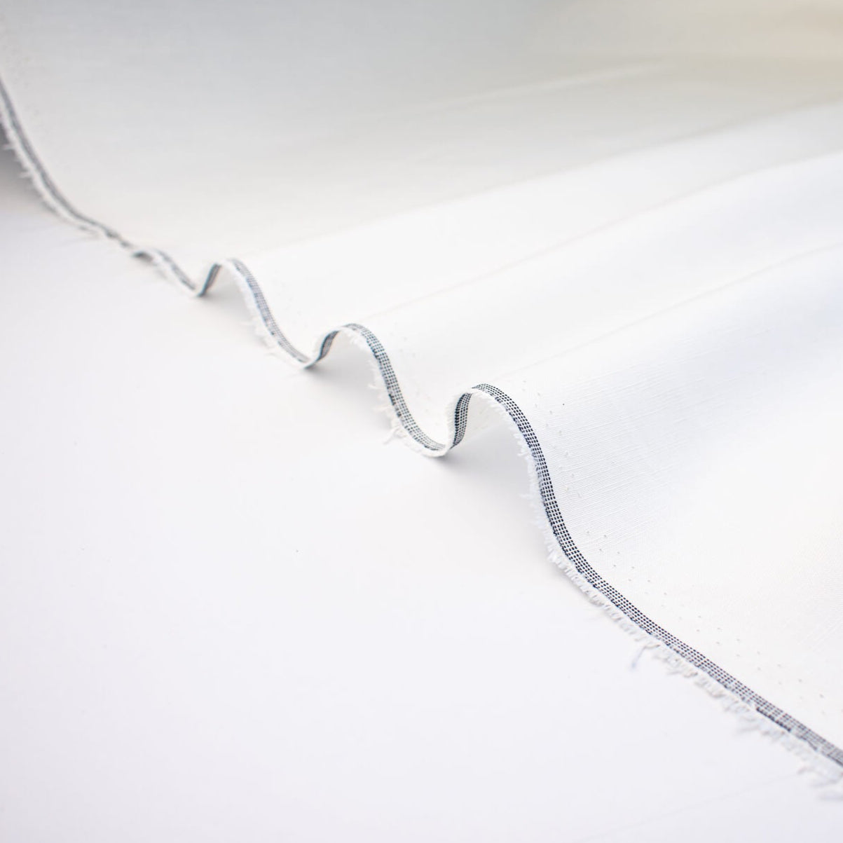 NYC Designer Linen blend designer deadstock fabric by the yard is the perfect fabric if you just love linen. &nbsp;A plain weave off-white fabric with a soft, slightly crisp hand.  Close up selvedge image.