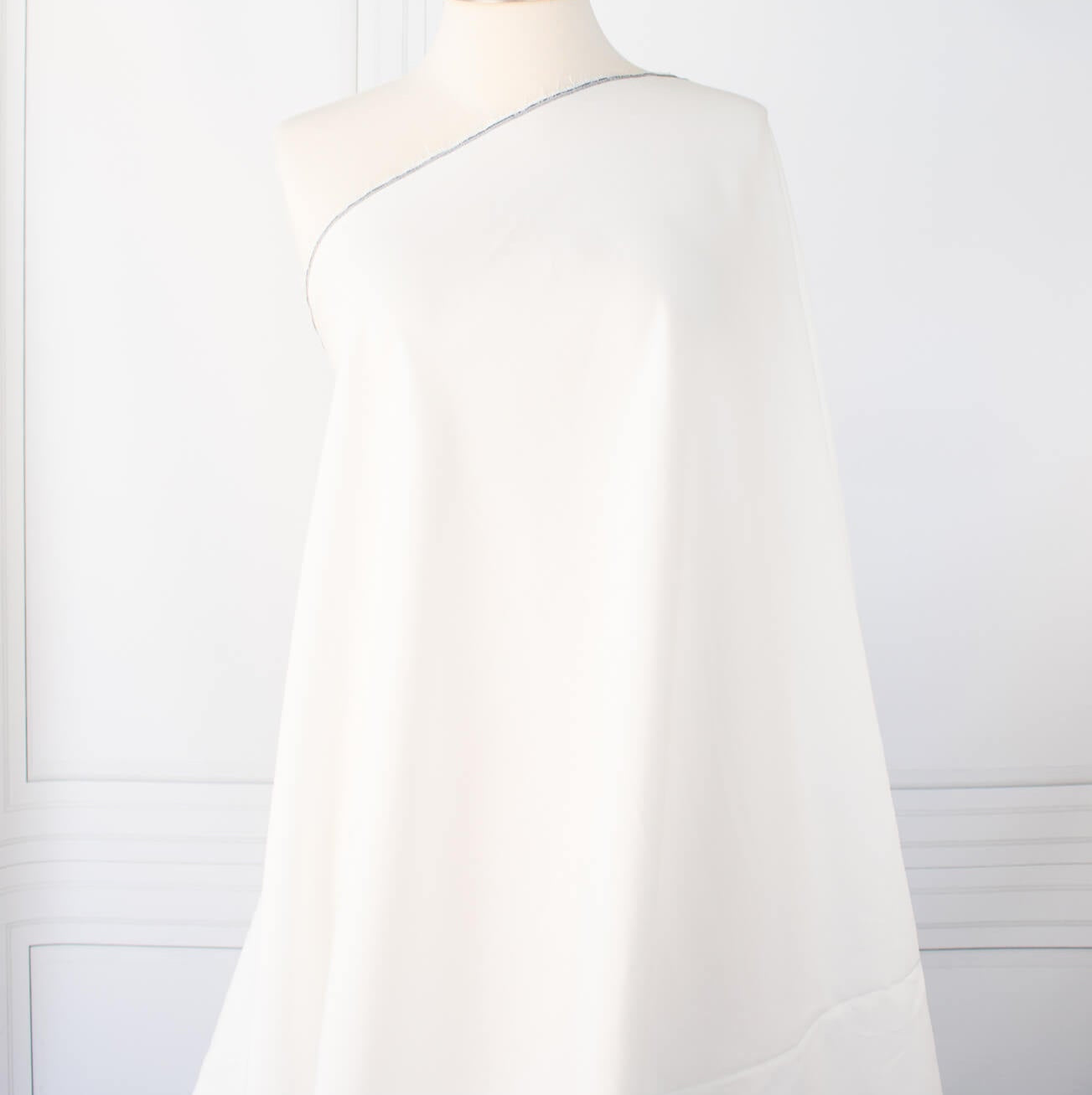 NYC Designer Linen blend designer deadstock fabric by the yard is the perfect fabric if you just love linen. &nbsp;A plain weave off-white fabric with a soft, slightly crisp hand.  Image of fabric draped on dressform.