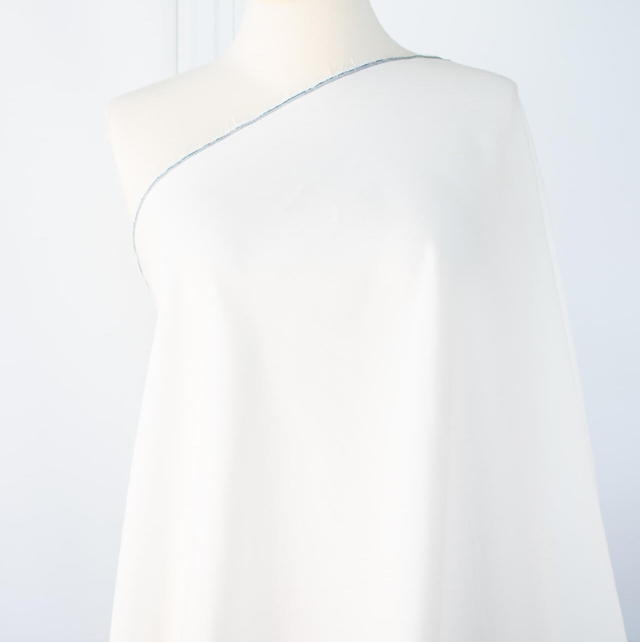 NYC Designer Linen blend designer deadstock fabric by the yard is the perfect fabric if you just love linen. &nbsp;A plain weave off-white fabric with a soft, slightly crisp hand.  Image of draped fabric on dressform.