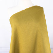 100% Linen Mid-Weight Woven fabric by the yard in a&nbsp;gorgeous golden green is a stunner and perfect for warmer weather. This plain weave linen is soft and has a crisp semi-textured hand. Create a lovely Jacket, Pant, Tunic or Vest! Image of fabric draped on dressform.