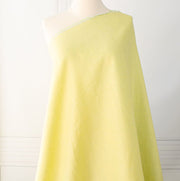 Made of 100% linen, this shirt-weight fabric features a gentle blend of spring green, white, and soft yellow tones, perfect for a stylish shirt, dress or skirt. Enjoy the lightweight, soft semi-crisp hand of this cross-dyed, woven fabric. Image of fabric draped on dressform.