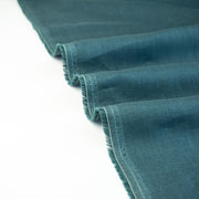 Harbor Blue 100% Linen shirt-weight woven fabric by the yard. Enjoy the soft and crisp hand and beautiful harbor blue hue that is sure to be a fantastic color to wake up your neutral pieces. Image of selvedge.