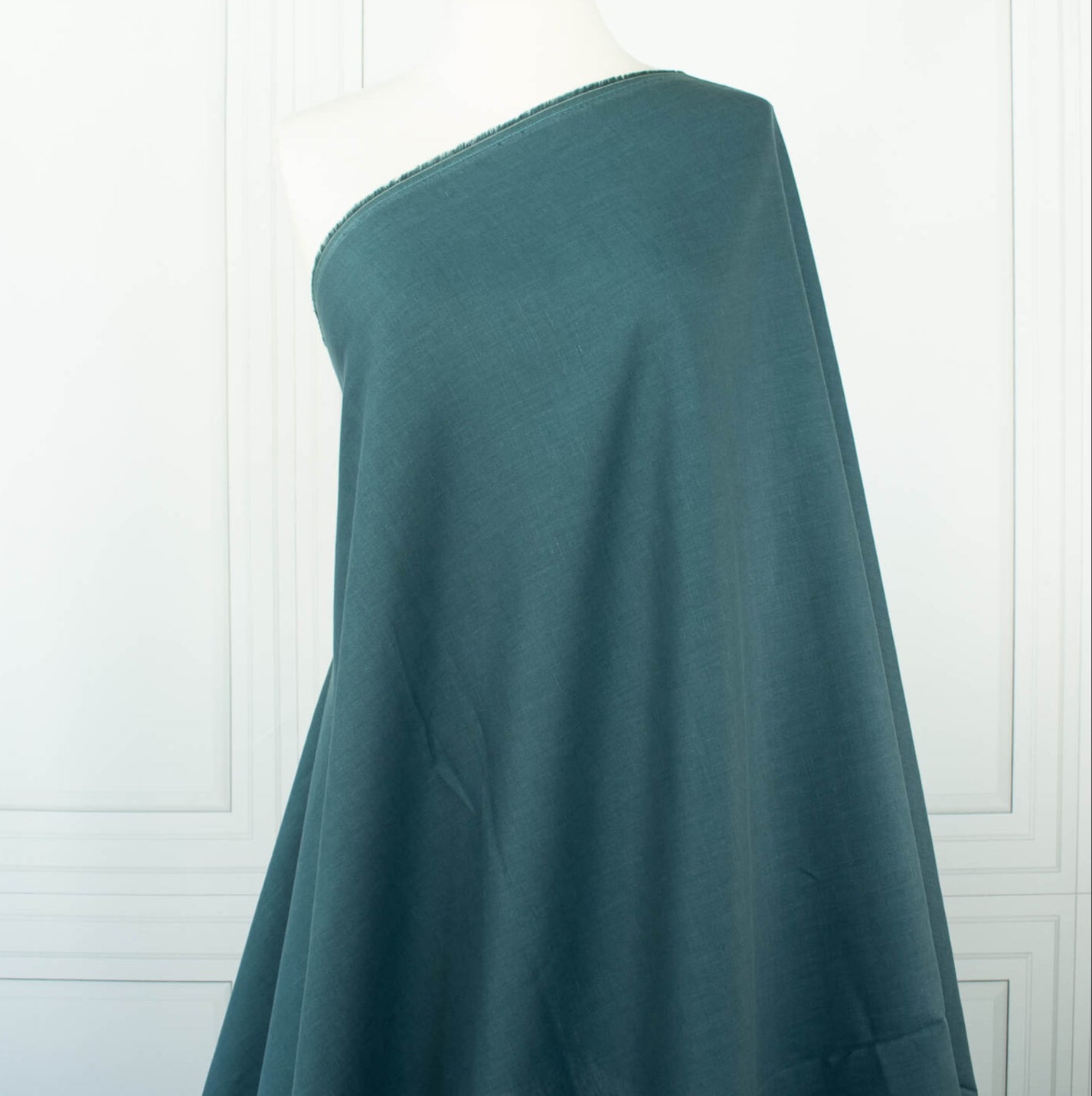 Harbor Blue 100% Linen shirt-weight woven fabric by the yard. Enjoy the soft and crisp hand and beautiful harbor blue hue that is sure to be a fantastic color to wake up your neutral pieces. Image of fabric on dressform.