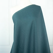 Harbor Blue 100% Linen shirt-weight woven fabric by the yard. Enjoy the soft and crisp hand and beautiful harbor blue hue that is sure to be a fantastic color to wake up your neutral pieces. Image of fabric draped on dressform.