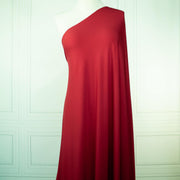 Warm red ITY jersey fabric draped on dressform