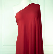 Warm red ITY jersey fabric draped on dressform