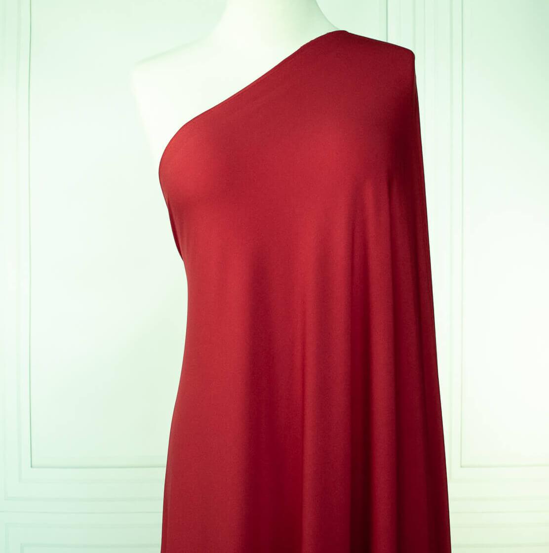 Warm red ITY jersey fabric draped on dressform