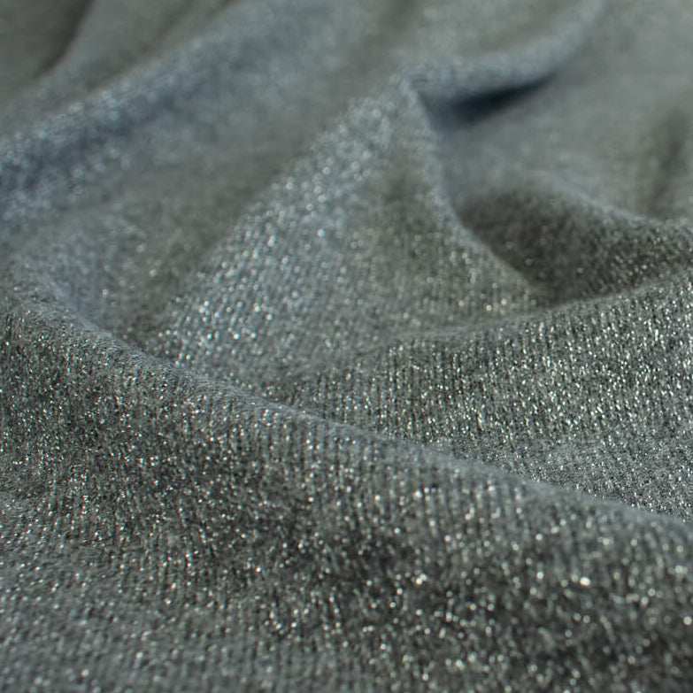 Close-up of  LA Designer Sweater Knit fabric by the yard! Create a beautiful essential in a soft gray and silver metallic rayon knit blend. 
