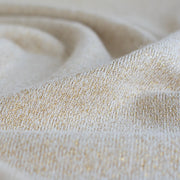 Close up of knit of  Designer White and Gold Metallic  Sweater knit fabric by the yard. 