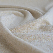 Close up of  Designer White and Gold Metallic Designer Sweater knit fabric by the yard. 