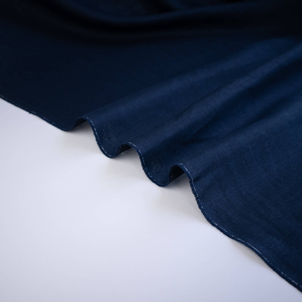 Close-up of dark blue linen fabric on a white background