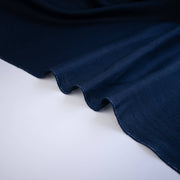 Close-up of dark blue linen fabric on a white background